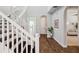 Bright foyer with staircase featuring white railings, wood floors, arched doorway, and natural light at 4719 Tramanto Ln, Wesley Chapel, FL 33543