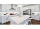 Modern white kitchen featuring stainless steel appliances, granite countertops, and a large center island with bar seating at 4719 Tramanto Ln, Wesley Chapel, FL 33543