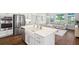 Modern kitchen with stainless steel appliances, a farmhouse sink, and an island with seating overlooking the open concept living area at 4719 Tramanto Ln, Wesley Chapel, FL 33543