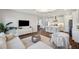 Spacious living room flows into kitchen and dining area, featuring modern decor, wood floors, and ample natural light at 4719 Tramanto Ln, Wesley Chapel, FL 33543
