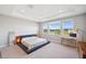 Bright main bedroom featuring serene lake views from large windows and stylish platform bed at 4719 Tramanto Ln, Wesley Chapel, FL 33543