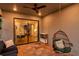 Cozy screened patio with ceiling fan, hanging chair, and view to the home's open floor plan through sliding glass doors at 4719 Tramanto Ln, Wesley Chapel, FL 33543