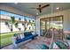 A stylish patio with blue sofa and hanging plants offers a relaxing spot with serene views at 4719 Tramanto Ln, Wesley Chapel, FL 33543