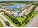 Aerial view of the neighborhood showcasing homes, a community pool, and a large lake, highlighting the community's amenities at 4744 Wandering Way, Wesley Chapel, FL 33544