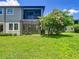 Green backyard with a screened patio and blooming tree on a partly cloudy day at 4744 Wandering Way, Wesley Chapel, FL 33544