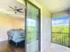 Balcony view from the main bedroom showcasing a picturesque scenery with blue sky and lush trees at 4744 Wandering Way, Wesley Chapel, FL 33544