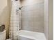 Bathroom featuring a tub and shower combination with a shower curtain and neutral tiles at 4744 Wandering Way, Wesley Chapel, FL 33544