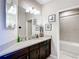 Bathroom with dark wood vanity, light colored countertop, and framed art in the toilet room at 4744 Wandering Way, Wesley Chapel, FL 33544