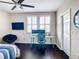 Bedroom with dark wood flooring, ceiling fan, and large window with plantation shutters at 4744 Wandering Way, Wesley Chapel, FL 33544