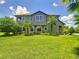 The two-story home features a well-maintained lawn, tropical palms, and a screened lanai, perfect for enjoying the outdoors at 4744 Wandering Way, Wesley Chapel, FL 33544