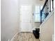 Bright foyer featuring wood-look tile flooring, staircase access to the second floor, and a front door at 4744 Wandering Way, Wesley Chapel, FL 33544