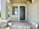 Close-up of the front door with stone accents, lush landscaping, and a window for natural light at 4744 Wandering Way, Wesley Chapel, FL 33544