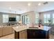 Open kitchen with stainless steel appliances, pendant lighting, and island sink overlooking the living area at 4744 Wandering Way, Wesley Chapel, FL 33544