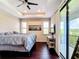 Main bedroom with tray ceilings, dark hardwood floors, and a private balcony overlooking beautiful views at 4744 Wandering Way, Wesley Chapel, FL 33544