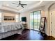 Spacious main bedroom with tray ceilings, dark hardwood floors, and access to a private balcony at 4744 Wandering Way, Wesley Chapel, FL 33544