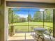 Screened-in patio with seating and a view of the lush green lawn and mature trees at 4744 Wandering Way, Wesley Chapel, FL 33544