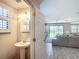 Charming powder room with a pedestal sink, neutral walls, and a clear view into the open living space at 4744 Wandering Way, Wesley Chapel, FL 33544