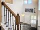 Staircase featuring wooden handrails, black iron balusters, and a view of the front door and foyer at 4744 Wandering Way, Wesley Chapel, FL 33544
