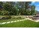 Backyard features green grass, pavers, seating area, and manicured landscaping at 4765 Lake Valencia W Blvd, Palm Harbor, FL 34684