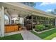Covered patio area with a hot tub, ceiling fan, and manicured landscaping at 4765 Lake Valencia W Blvd, Palm Harbor, FL 34684