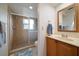 Cozy bathroom featuring wood cabinets, a framed mirror, and a shower with glass door at 4765 Lake Valencia W Blvd, Palm Harbor, FL 34684