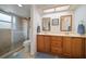 Bright bathroom with double sinks, a walk-in shower, and wooden cabinetry at 4765 Lake Valencia W Blvd, Palm Harbor, FL 34684