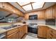 Well-lit kitchen featuring stainless steel appliances, light wood cabinetry, and an open view into the living room at 4765 Lake Valencia W Blvd, Palm Harbor, FL 34684