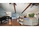 Spacious living room featuring vaulted ceilings, exposed beams, a piano, fireplace, and comfortable seating at 4765 Lake Valencia W Blvd, Palm Harbor, FL 34684