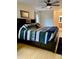 Bright main bedroom featuring a bed with storage, wood floors, and a ceiling fan at 4765 Lake Valencia W Blvd, Palm Harbor, FL 34684