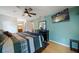 Comfortable bedroom with wood floors, a mounted TV, ceiling fan, and view of the en-suite bath at 4765 Lake Valencia W Blvd, Palm Harbor, FL 34684