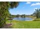 Scenic view of a pond with a fountain, lush greenery, and a bench at 4765 Lake Valencia W Blvd, Palm Harbor, FL 34684