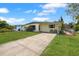 Inviting front of a one-story home with lush green lawn and long concrete driveway at 4932 Murray Hill Dr, Tampa, FL 33615