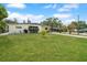 View of the front yard of a house with a well-maintained lawn and mature trees at 4932 Murray Hill Dr, Tampa, FL 33615