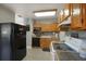 Traditional-style kitchen with wooden cabinets, granite countertops, and black refrigerator at 4932 Murray Hill Dr, Tampa, FL 33615