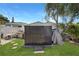 Backyard features a storage shed, surrounded by lush green lawn and mature trees at 4932 Murray Hill Dr, Tampa, FL 33615