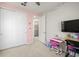 Bright bedroom featuring plush carpet, a pink accent wall, and a desk at 5733 Colony Glen Rd, Lithia, FL 33547