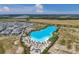 An aerial view showcases a blue lagoon surrounded by palm trees and a neighborhood of white homes in a rural area at 5917 Cat Claw Ln, Bradenton, FL 34210