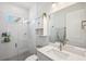 Modern bathroom with a walk-in shower, white tile, decorative hanging plants and a sleek vanity at 5917 Cat Claw Ln, Bradenton, FL 34210
