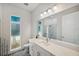 Bright bathroom featuring modern fixtures, a large mirror, ample counter space, and a glass shower at 5917 Cat Claw Ln, Bradenton, FL 34210