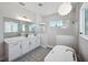 Bathroom with standalone tub, glass shower, white cabinets, and patterned floors at 5917 Cat Claw Ln, Bradenton, FL 34210