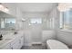 Bathroom featuring a standalone tub, a glass enclosed shower, and dual vanities at 5917 Cat Claw Ln, Bradenton, FL 34210