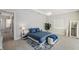 Well-lit bedroom featuring a blue bed, light wood floors, and stylish furniture at 5917 Cat Claw Ln, Bradenton, FL 34210