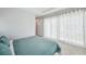 Bright bedroom featuring large window dressed with long white curtains and aqua-colored bedding at 5917 Cat Claw Ln, Bradenton, FL 34210