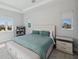 Brightly lit bedroom featuring large windows, a side table, and comfortable king-size bed at 5917 Cat Claw Ln, Bradenton, FL 34210