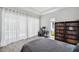 Bright bedroom with sheer curtains, a bookshelf, a modern desk, and light gray wood-look tile flooring at 5917 Cat Claw Ln, Bradenton, FL 34210