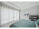A well-lit bedroom featuring window views, curtains, and comfortably made bedding at 5917 Cat Claw Ln, Bradenton, FL 34210