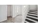 Bright entryway with a staircase, wood-look tile flooring, white trim, and a glass front door at 5917 Cat Claw Ln, Bradenton, FL 34210