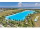 Aerial view of a lagoon surrounded by palm trees and green space near residential properties and a view of the ocean at 5917 Cat Claw Ln, Bradenton, FL 34210