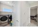 Bright laundry room featuring a washer and dryer, with shelving for storage at 5917 Cat Claw Ln, Bradenton, FL 34210