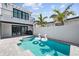 Backyard pool with modern home exterior, featuring swan floats, palm trees, and blue skies at 5917 Cat Claw Ln, Bradenton, FL 34210